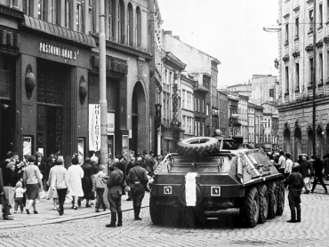 Sovětský obrněný transportér na náměstí Míru (nyní Horním náměstí) před budovou Poštovního úřadu 3. Státní okresní archiv v Olomouci.